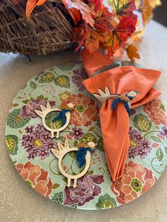 two napkins are sitting on a plate next to some flowers