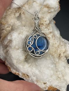 This is a beautiful blue Labradorite moon pendant in Sterling Silver. A complimentary stainless steel chain is included and a gift box, ready for shipping.  All of my pieces are made with high quality wire from Riogrande. These are not costume pieces that will chip away or rust over time. They will last forever if taken care of, which is why I include a free polishing cloth with every order. Quality is very important to me.  If you have any questions, I'm happy to help Wire Wrapped Round Pendant Jewelry As Gift, Wire Wrapped Pendant Jewelry Gift, Wire Wrapped Pendant Jewelry For Gifts, Mystical Silver Jewelry Gift, Silver Jewelry With Moon Charm For Gift, Mystical Silver Jewelry For Gifts, Celestial Stainless Steel Necklaces As Gift, Celestial Stainless Steel Necklace For Gifting, Celestial Stainless Steel Necklace As Gift