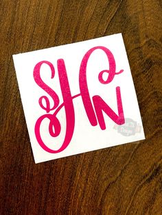 a close up of a sticker on a wooden surface with the letter s and n