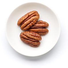 four pecans on a white plate