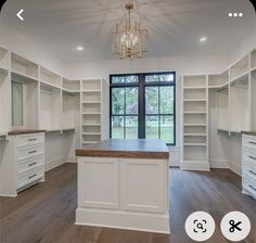 an empty walk - in closet with white cabinets and wood flooring is featured on the phone