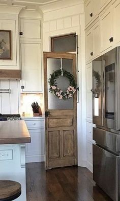 a kitchen with white cabinets and stainless steel refrigerator freezer next to an open door