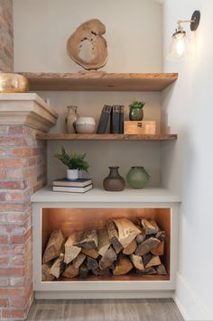 there is a firewood rack in the corner of this room with books and vases on it