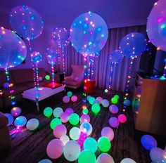 the room is filled with glowing balloons and streamers on the floor, as well as couches