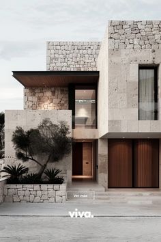 a modern house with stone walls and wooden doors