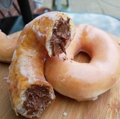 there are two donuts with chocolate frosting on them and one is half eaten