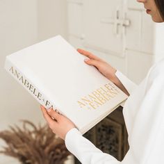 a woman is holding a book in her hands