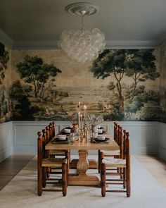 a dining room table with chairs and a chandelier hanging from it's ceiling