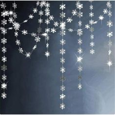 snowflakes are hanging from the ceiling in front of a black background with white stars