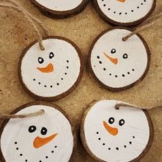 four snowman ornaments are hanging from twine on the floor, with string attached to them