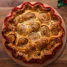 a person cutting into a pastry on top of a wooden table next to holly branches