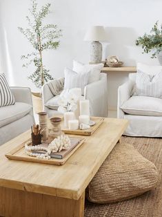 a living room with couches, tables and pillows on the floor in front of them