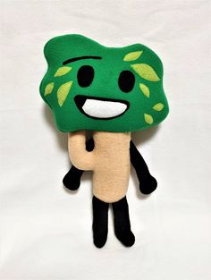 a stuffed animal with a green leaf on it's head and eyes, holding a banana