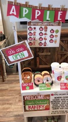 an apple stand with signs and donuts on it