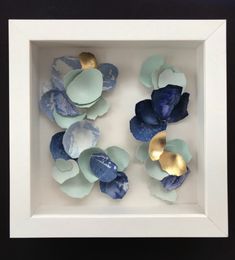 some blue and gold flowers in a white frame