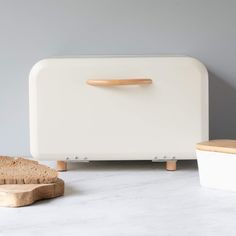 a white bread dispenser sitting on top of a counter next to a loaf of bread