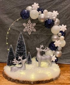 a christmas wreath made out of snow and silver ornaments on top of a wooden table