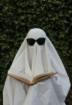 a book shaped like a ghost with sunglasses on it's head, reading a book