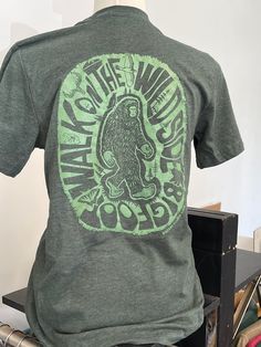 Walk on the Wild Side with this unique, art designed Bigfoot t-shirt. Hand drawn and screen printed on a high quality Next Level t-shirt on the front and back. All sizes are unisex. Orders over $35 ship for FREE! Bigfoot T Shirt, Bigfoot Shirt Ideas, Bigfoot Shirts, Bigfoot Party, Bigfoot Shirt, Shirt Inspiration, Pigeon Forge Tn, Bigfoot Sasquatch, Walk On The Wild Side