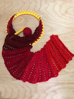 a crocheted red shawl with a ball of yarn on it and the text, stitch video live now