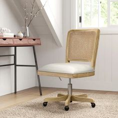 an office chair sitting on top of a rug in front of a desk and window