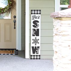 a sign that says let it snow on the front porch next to a door way