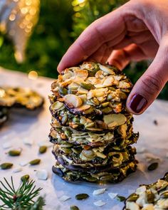 a stack of cookies sitting on top of a table covered in nuts and other toppings