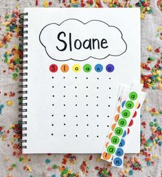 a notebook with the word sloane written on it next to some sprinkles