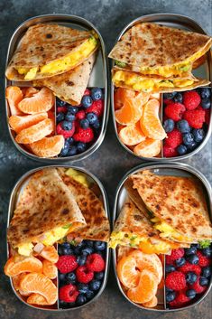 four trays filled with different types of food and fruit on top of each other