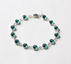 "This emerald bracelet features faceted Swarovski crystals in emerald green, May's birthstone, set in silver and finished with a lobster clasp. The bracelet measures 7 1/4\" in total length. Please put a note in at checkout if you need a different length. The Swarovski crystals are 6mm across. The last photo shows the Swarovski birthstone colors available in this style, in my shop: https://www.etsy.com/shop/SprigJewelry/search?search_query=birthstone+bracelet+delicate Other birthstone jewelry st May Birthstone Crystal Gemstone Bracelet, Classic Green May Birthstone Bracelets, Silver Emerald Bracelet Jewelry, Green Faceted Crystal Bracelet For Jewelry Making, Silver Emerald Bracelets As Gift, Silver Birthstone Crystal Bracelet For Jewelry Making, Luxury Emerald Bracelets For May Birthstone, Green Sterling Silver Bracelets For May Birthstone, Luxury Green Bracelet For May Birthstone