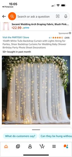 the wedding arch is decorated with white flowers and fairy lights