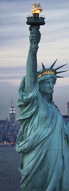 the statue of liberty is lit up at night