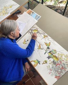 an older woman is working on some artwork