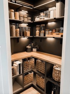 an organized pantry with lots of food in baskets and containers on the shelves, along with other items