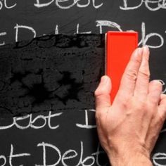 a person is writing on a blackboard with chalk and a red eraser in front of it