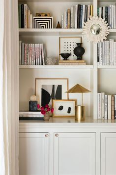 a white bookcase filled with lots of books