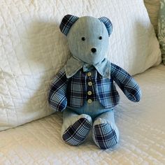 a blue teddy bear sitting on top of a bed