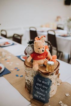 a teddy bear sitting on top of a tree stump