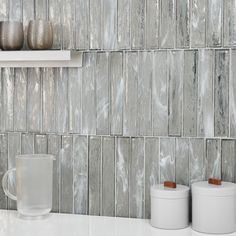 a kitchen counter with two mugs on top of it and some cups next to it