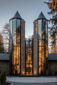 two large round glass windows in front of a stone building with trees on the other side