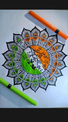 an orange and green pen sitting on top of a drawing