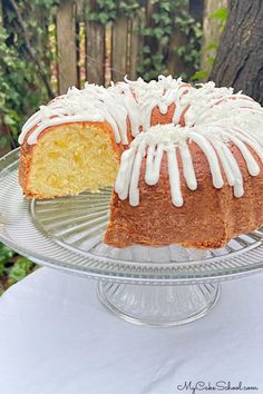 a bundt cake with white icing sitting on top of a glass platter