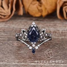 a blue diamond ring sitting on top of a wooden table