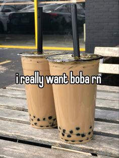 two iced coffees sitting on top of a wooden table with the words i really want boba n