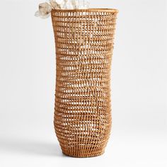 a wicker basket with tissue paper in it and a white flower on the top