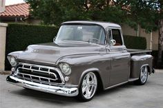 an old gray truck parked in front of a house