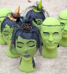 several green plastic heads with faces painted on them