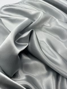 Silver crepe back satin This high-quality satin fabric is a perfect choice for any project that requires a touch of elegance and sophistication. The 58-inch width make it suitable for a wide range of applications, from apparel to home decor and crafts. The fabric comes in a beautiful shade of silver, which adds a classy and luxurious feel to any design. Ideal for use in bridal dresses, blazers, curtains, and even marquees, this shiny crepe back satin fabric offers excellent drape and durability. Whether you are a professional designer or a DIY enthusiast, this fabric is sure to inspire your creativity and help you create stunning and unique creations. Get your hands on this gorgeous fabric today and let your imagination run wild! Delivery All items are dispatched within 1-2 working days. A Wedding Dress Material, Deco Dress, Colour Matching, Back Stretches, Silver Fabric, Stretch Crepe, Gorgeous Fabrics, Shiny Silver, Luxury Fabrics