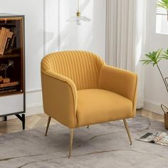 a yellow chair sitting on top of a rug next to a book shelf