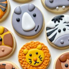 several decorated cookies are arranged on a white surface with tiger, lion and giraffe designs